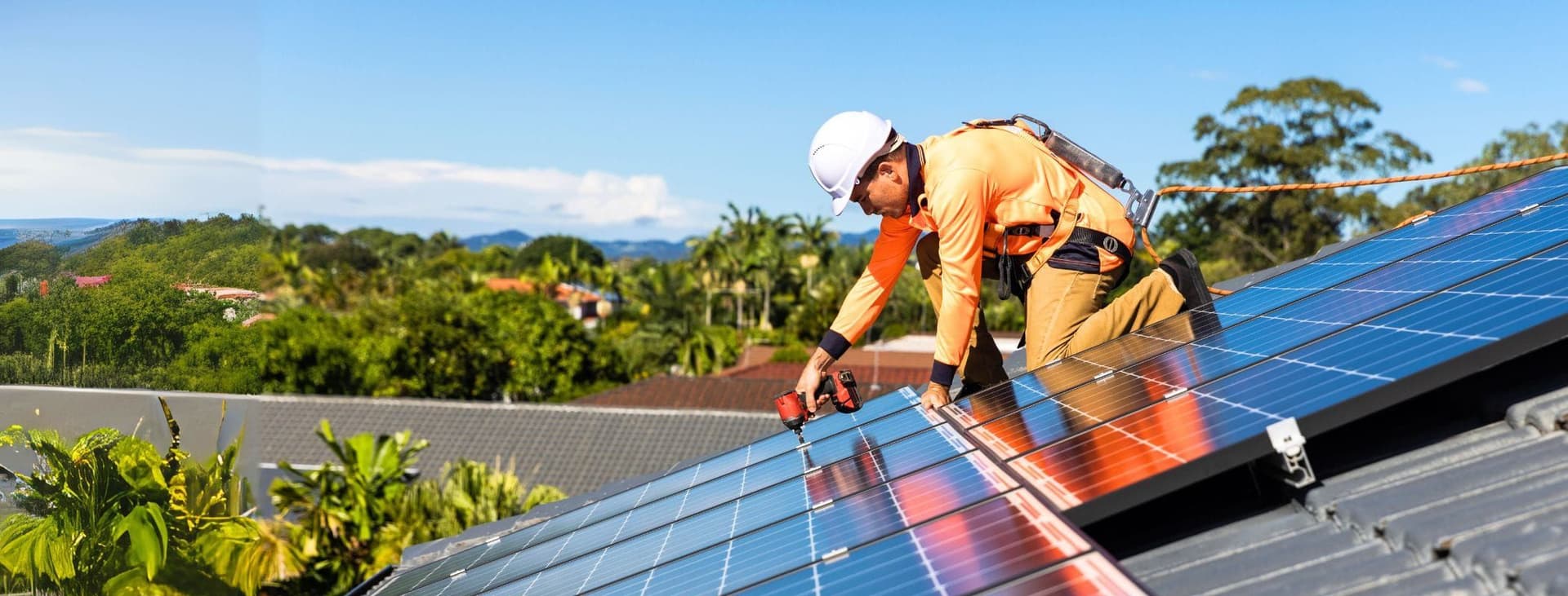 Man at Work Fixing Solar Panels on Roof
